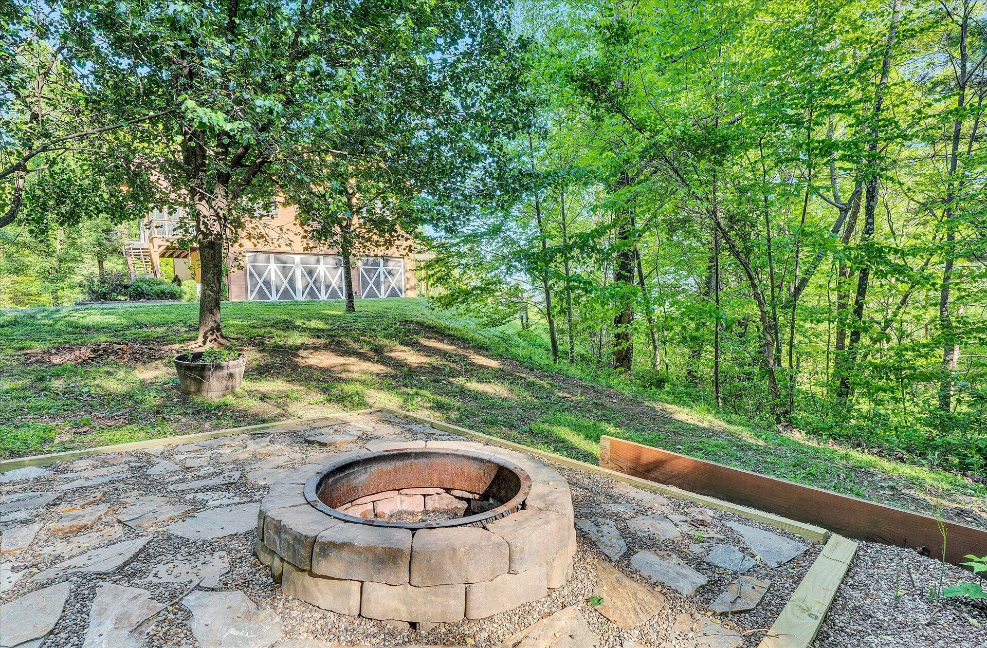 4939 Wade Road Roanoke, VA 24018 - Photo 49 of 57 a view of a backyard with table and chairs potted plants and large tree