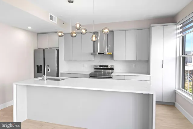 a kitchen with stainless steel appliances a sink stove and refrigerator