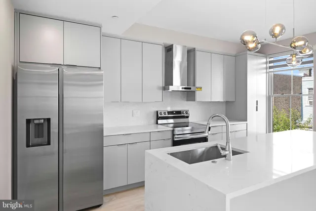 a kitchen with a refrigerator a sink and cabinets