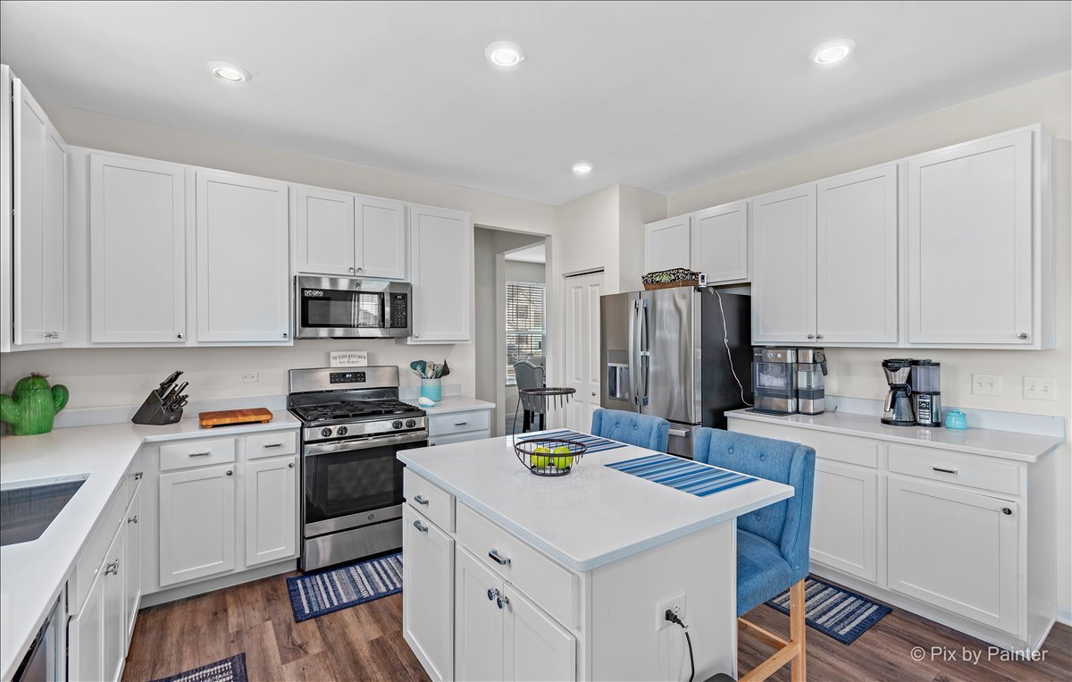 1315 Sage Circle Joliet, IL 60431 - Photo 9 of 27 a kitchen with a sink a stove a refrigerator a center island and cabinets
