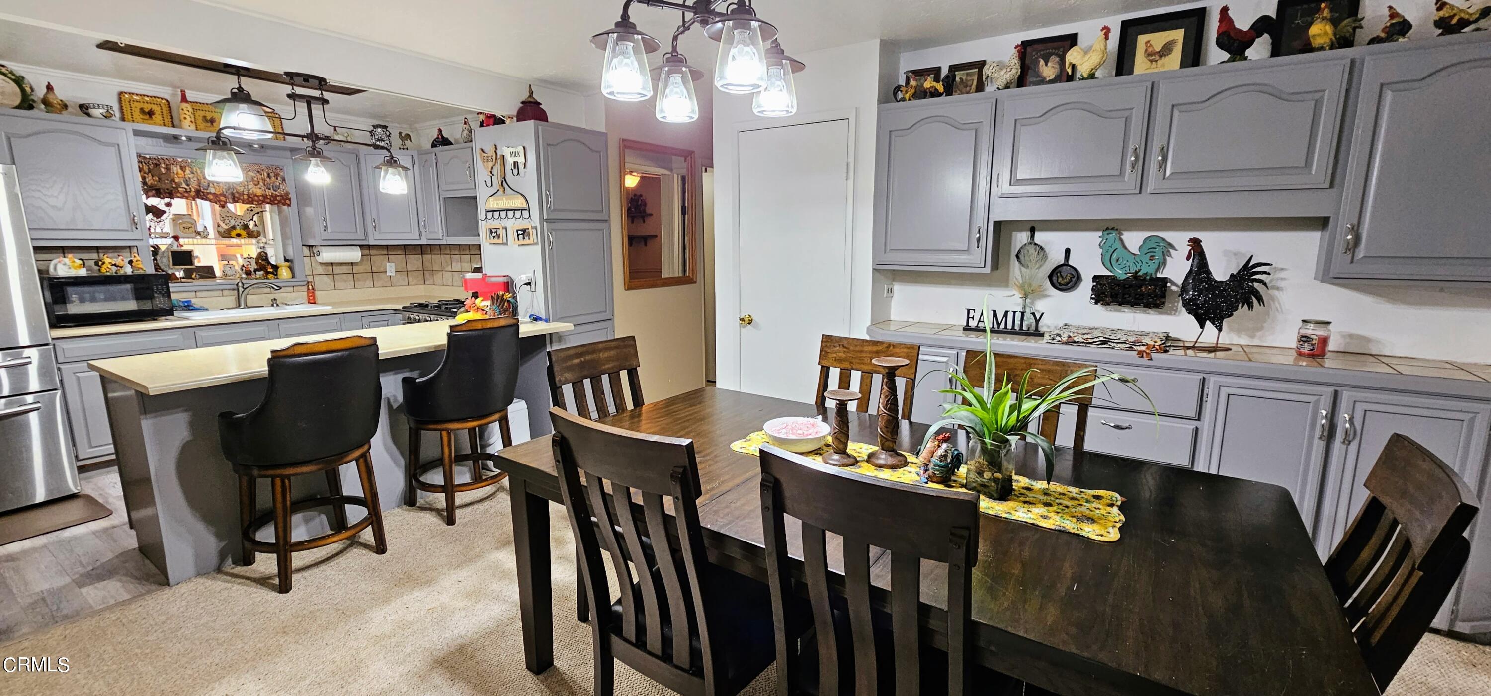 1157 Eugene Maricopa Ca Maricopa, CA 93252 - Photo 6 of 28 a kitchen with stainless steel appliances granite countertop a dining table chairs refrigerator and sink