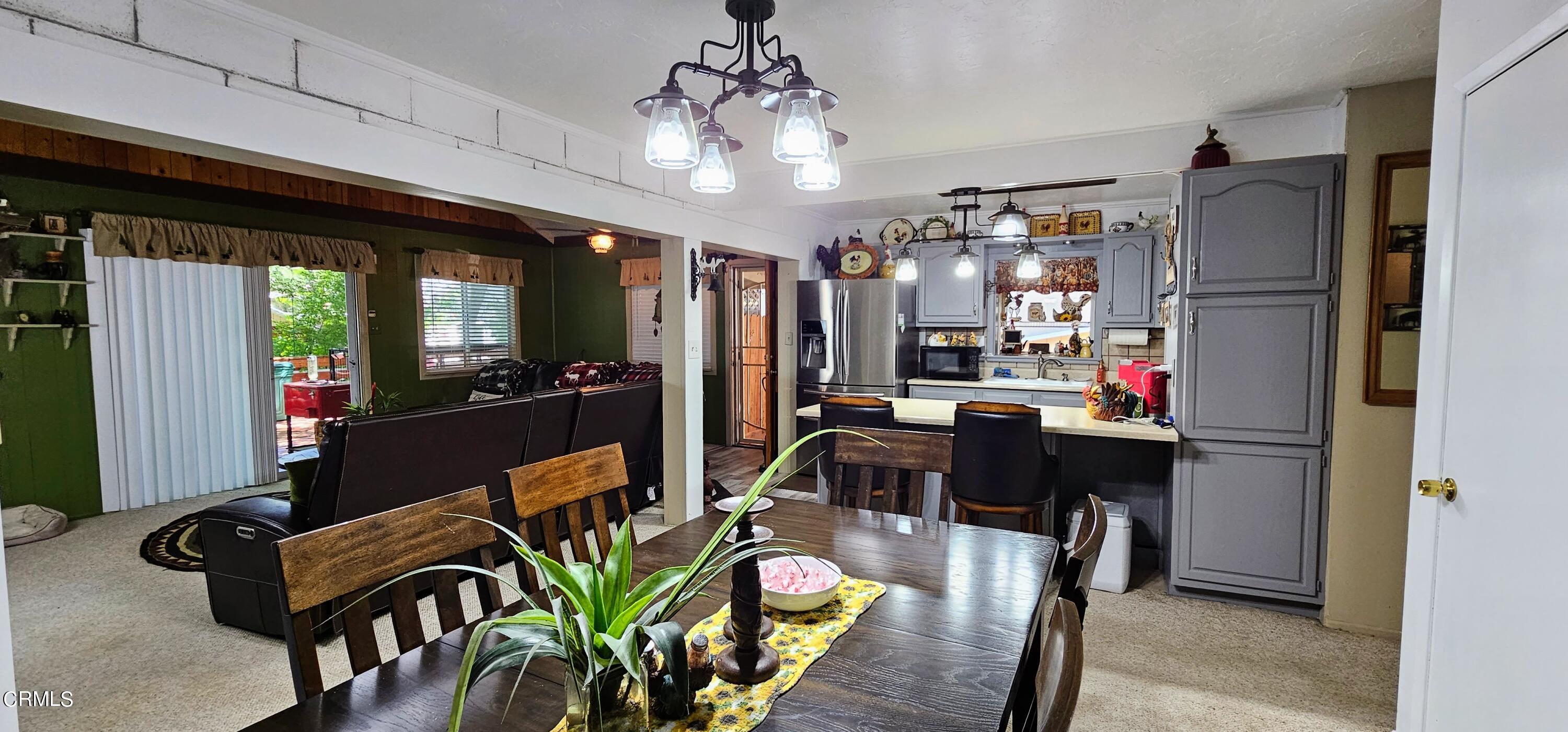 1157 Eugene Maricopa Ca Maricopa, CA 93252 - Photo 7 of 28 a view of a dining room with furniture a kitchen and chandelier