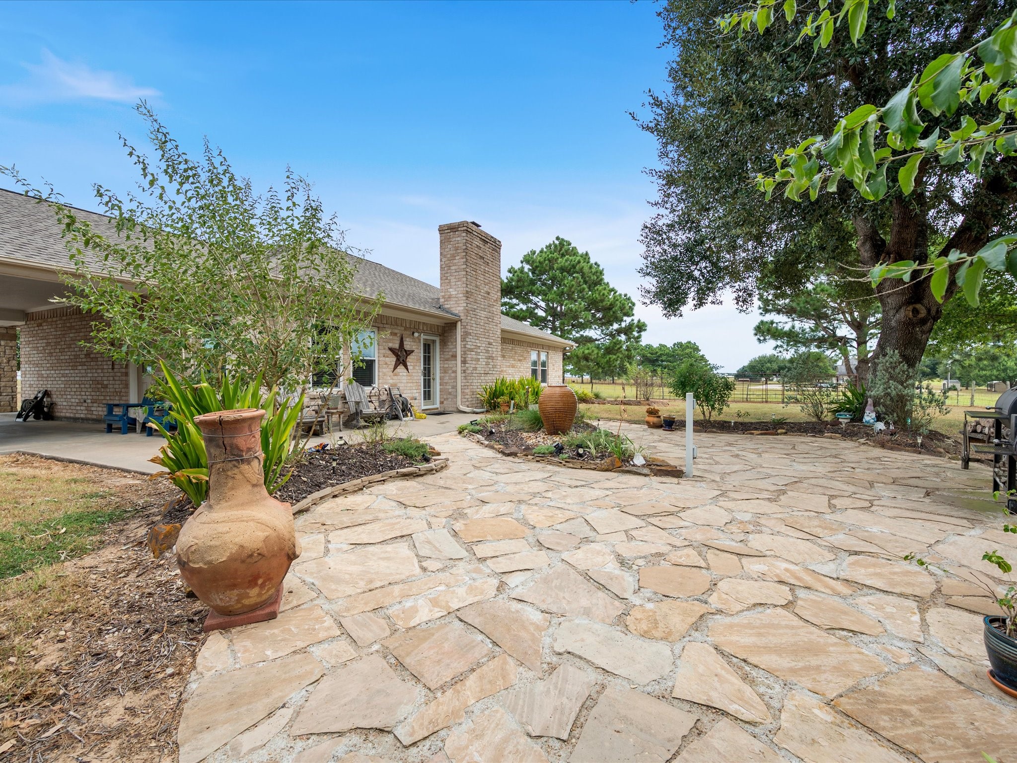 19929 Pierceall Road Hempstead, TX 77445 - Photo 28 of 50 Step outside to an expansive flagstone patio offering plenty of room to relax, dine, and enjoy the peaceful surroundings.