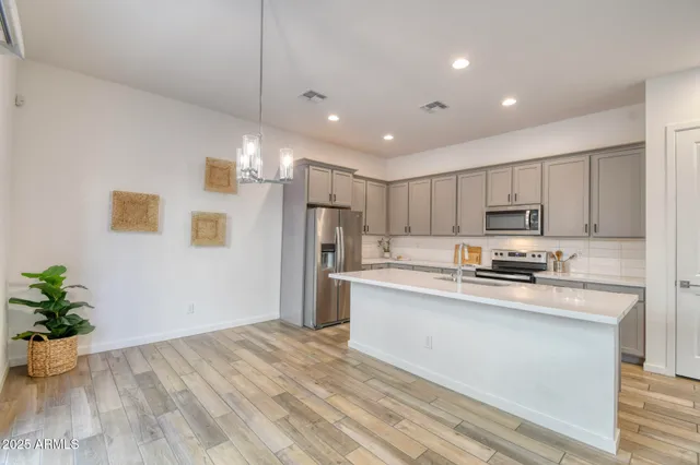 a kitchen with stainless steel appliances a refrigerator sink and microwave