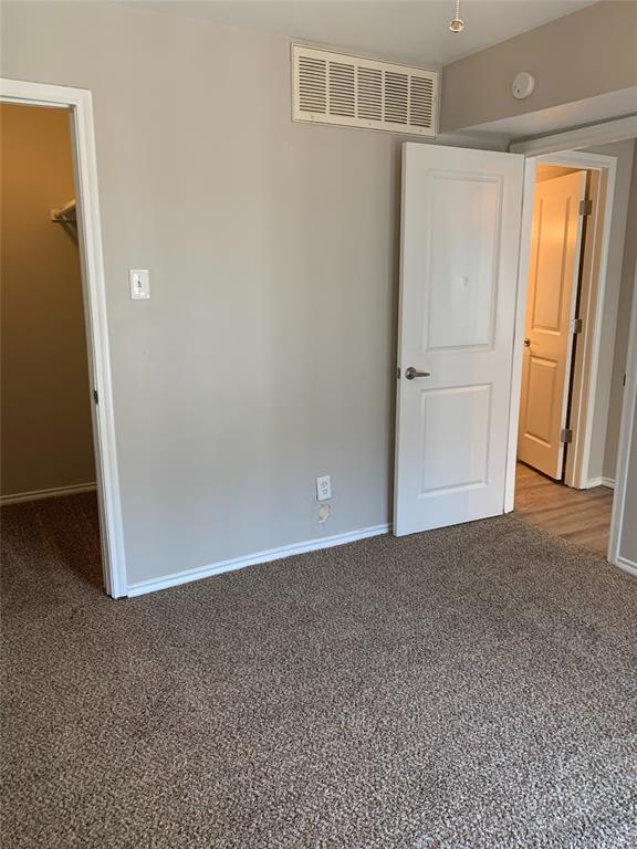 4622 Monarch Street, Unit 106 Dallas, TX 75204 - Photo 11 of 12 Unfurnished bedroom with a walk in closet and carpet