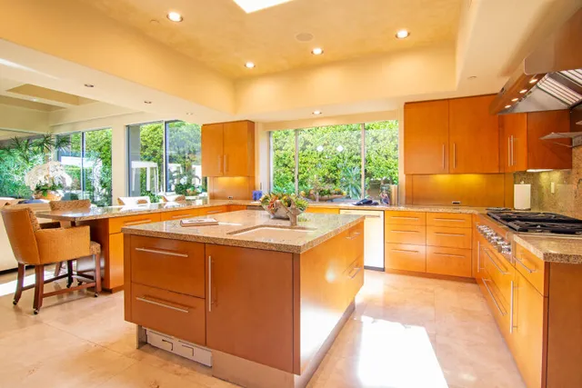 a living room with furniture kitchen view and a large window
