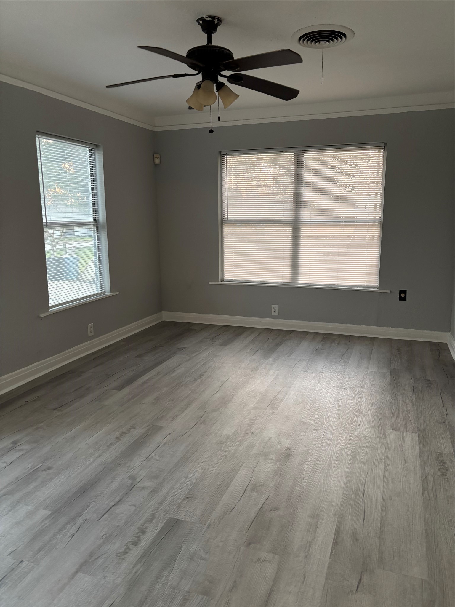 10523 Oswego Street Houston, TX 77029 - Photo 4 of 11 an empty room with wooden floor and windows