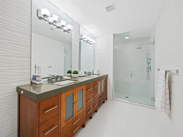 a bathroom with a sink double vanity granite tub and shower