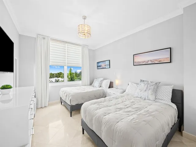 a bedroom with two beds and a window