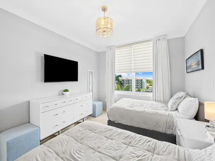 a bedroom with a bed and a flat tv screen on dresser