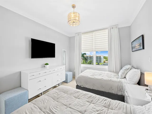 a bedroom with a bed and a flat tv screen on dresser