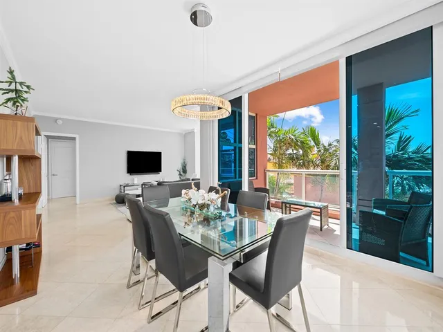 a dining room with furniture a flat screen tv and a floor to ceiling window