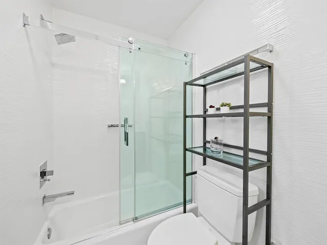 a bathroom with a shower toilet and a bath tub