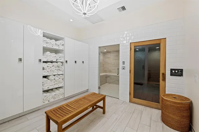 a hallway with a large mirror and a glass door shower