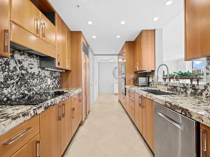a large kitchen with stainless steel appliances kitchen island granite countertop a sink and cabinets