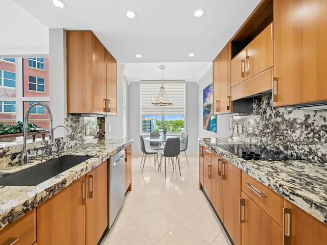 a large kitchen with stainless steel appliances granite countertop a lot of counter space and a sink