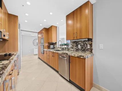 a kitchen with stainless steel appliances granite countertop a stove a sink and a refrigerator