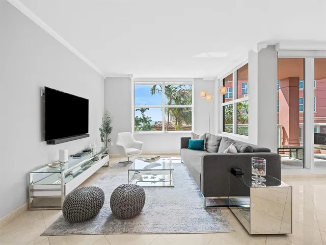 a living room with furniture a flat screen tv and a floor to ceiling window