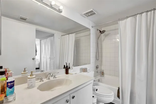 a kitchen with stainless steel appliances granite countertop a refrigerator a stove a sink dishwasher and white cabinets with wooden floor