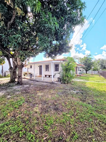 a view of a yard with plants and trees