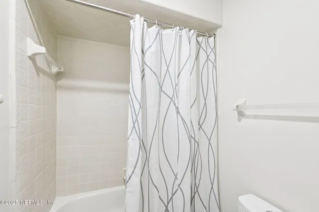 a bathroom with a shower curtain and a toilet