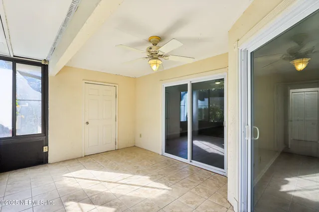 a view of a hallway with a chandelier fan and windows