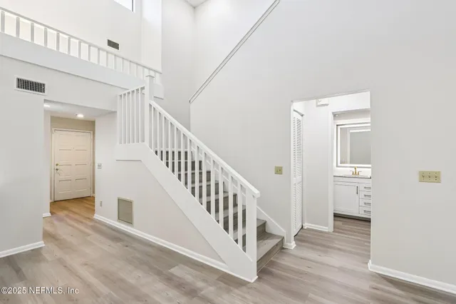 a view of a hallway with an entryway and wooden floor