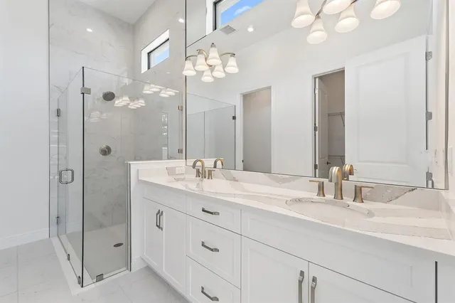 a bathroom with a double vanity sink mirror and shower