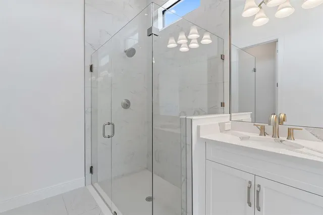 a bathroom with a shower a sink and a mirror