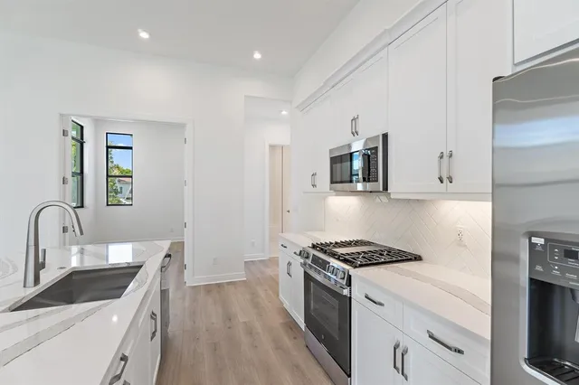 a kitchen with granite countertop a sink stove and cabinets