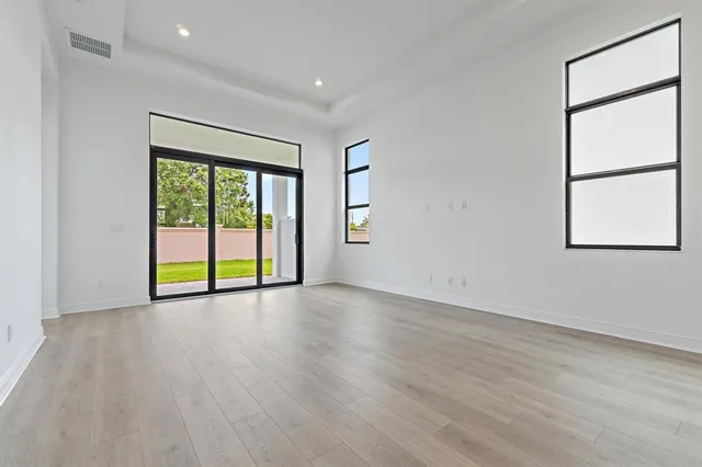 an empty room with wooden floor and doors