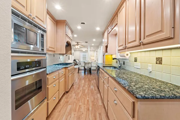 a kitchen with stainless steel appliances granite countertop a stove a sink and a microwave