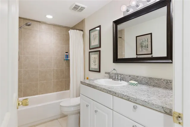 a bathroom with a granite countertop sink a toilet and shower