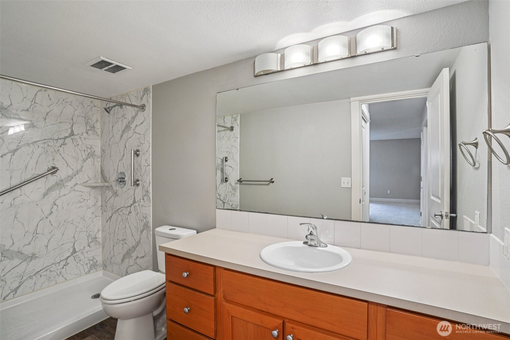 8025 234th Street Southwest, Unit 116 Edmonds, WA 98026 - Photo 12 of 26 a bathroom with a granite countertop sink a toilet and a mirror