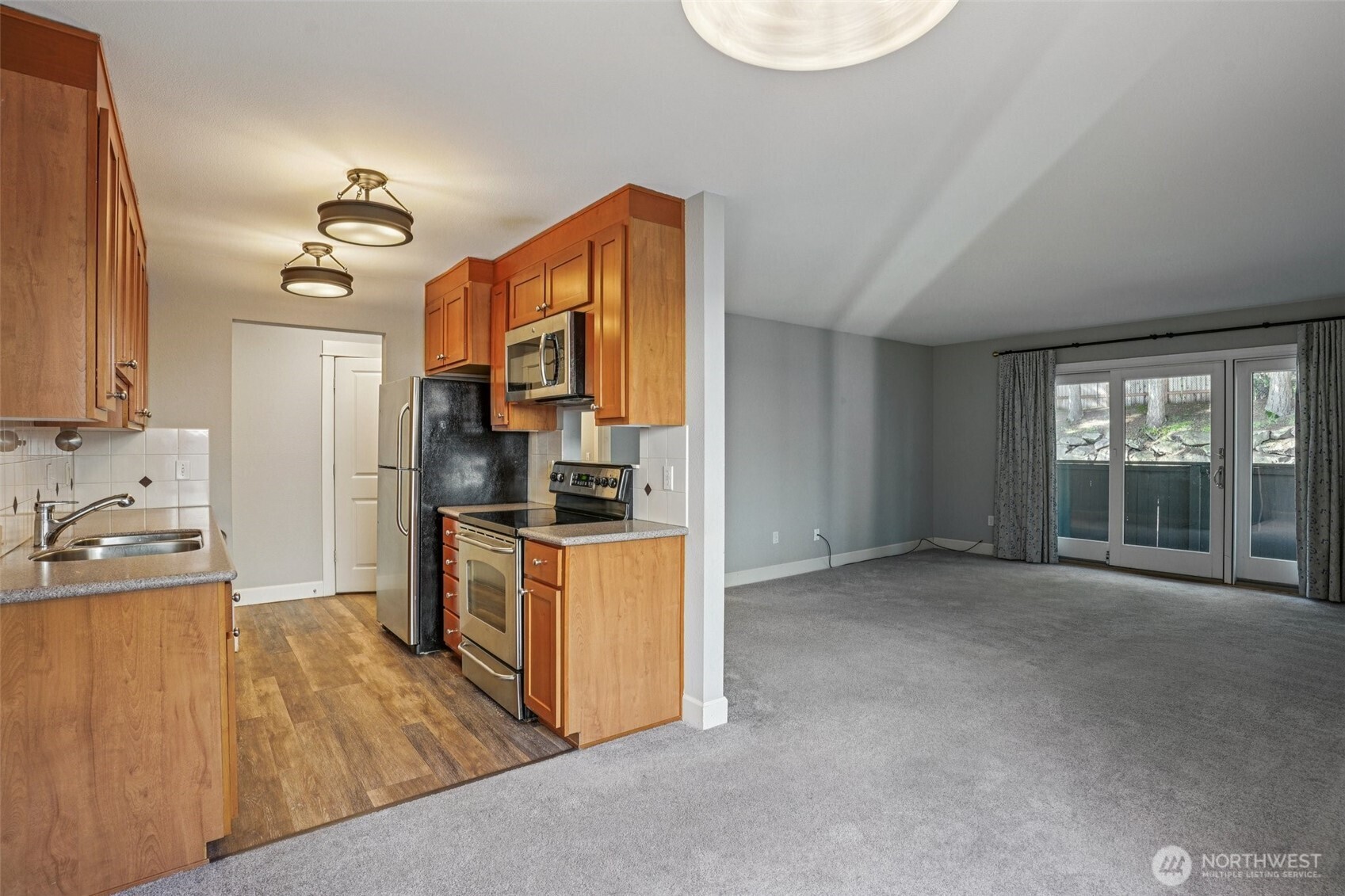 8025 234th Street Southwest, Unit 116 Edmonds, WA 98026 - Photo 6 of 26 a view of a kitchen with a sink dishwasher and a refrigerator