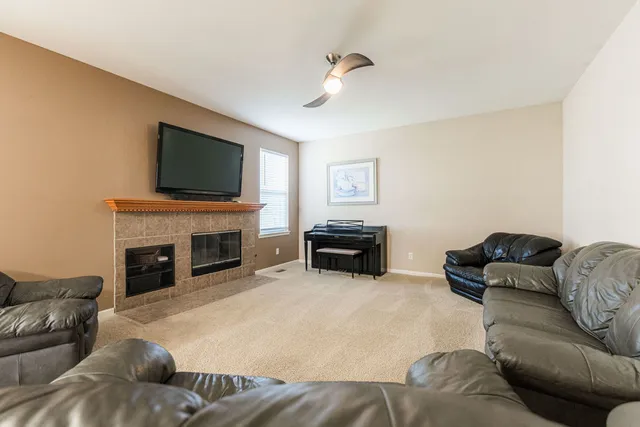 a living room with furniture a fireplace and flat screen tv