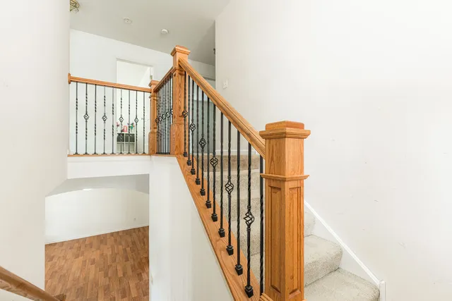 a view of a hallway with wooden floor and staircase