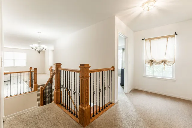 an empty room with windows & stairs