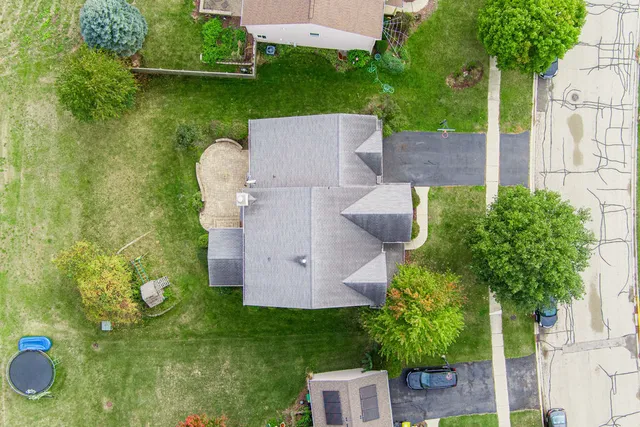 an aerial view of a house with garden space and trees all around