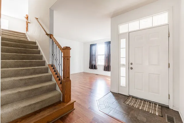 a view of entryway with wooden floor and stairs