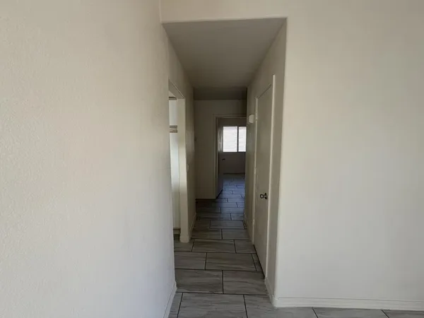 a view of a hallway with wooden floor and a door