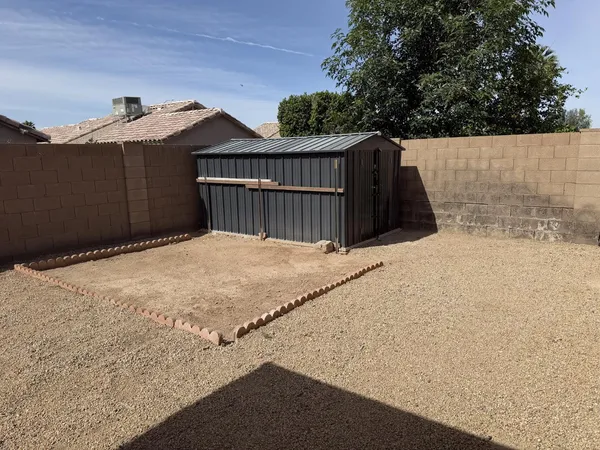 a view of backyard with wooden fence and large trees