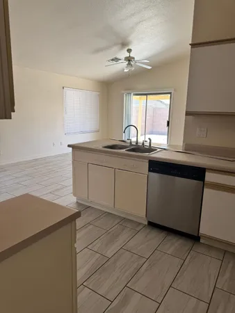 a kitchen with a sink a stove cabinets and a window