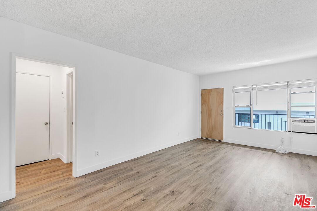 1812 North Gramercy Place, Unit 11 Los Angeles, CA 90028 - Photo 4 of 18 a view of an empty room with wooden floor and a window