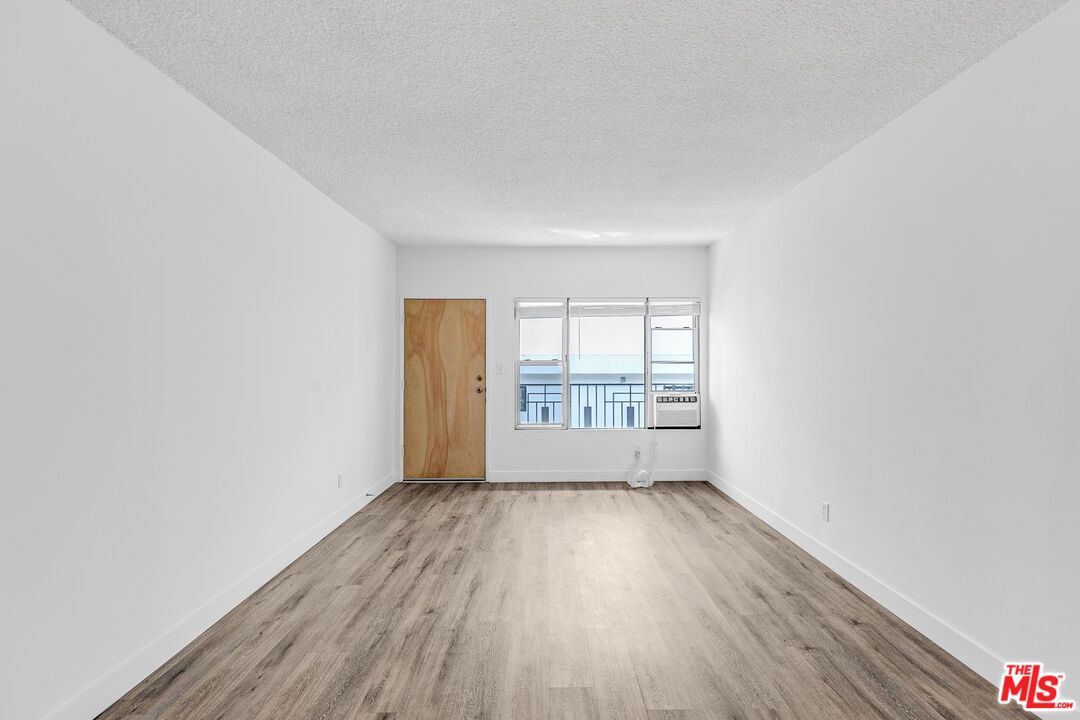 1812 North Gramercy Place, Unit 11 Los Angeles, CA 90028 - Photo 5 of 18 an empty room with wooden floor and windows