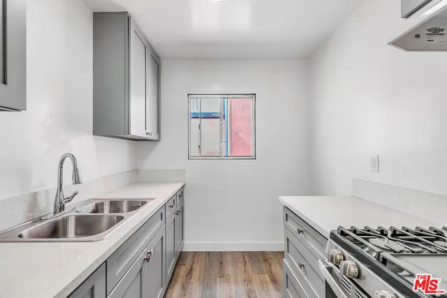 a kitchen with a sink stove top oven and cabinets