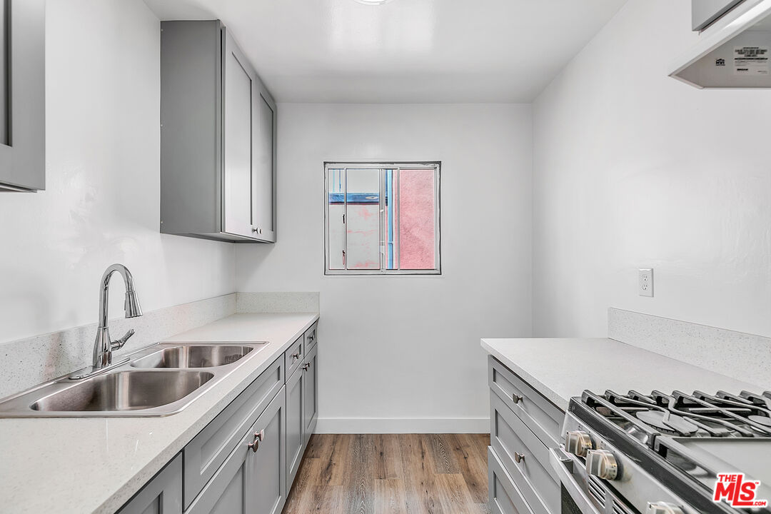 1812 North Gramercy Place, Unit 11 Los Angeles, CA 90028 - Photo 6 of 18 a kitchen with a sink stove top oven and cabinets