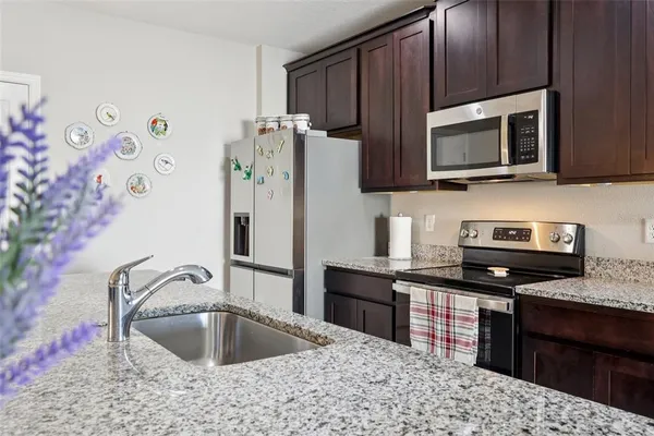 a kitchen with stainless steel appliances granite countertop a sink stove and refrigerator