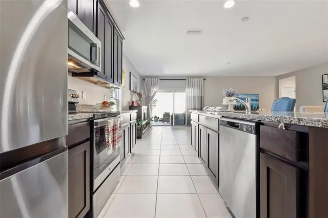 a kitchen with stainless steel appliances granite countertop a refrigerator and a stove top oven