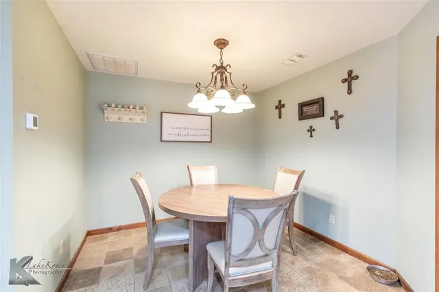 a dining room with a wooden table and chairs